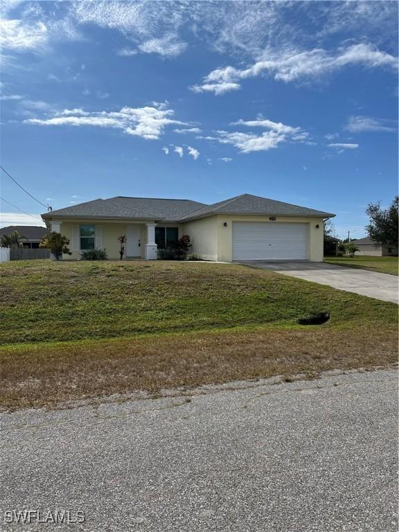 single story home featuring a front lawn and a garage