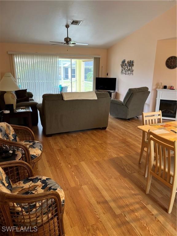 living room with ceiling fan and light hardwood / wood-style flooring