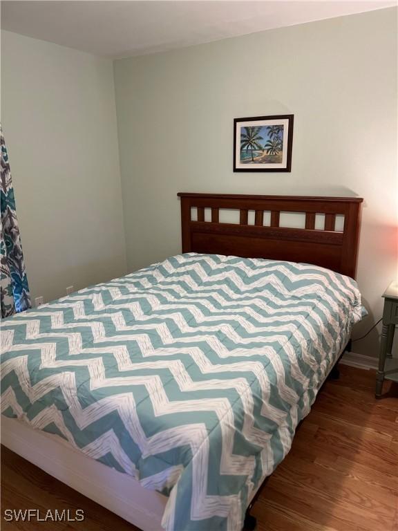 bedroom with dark hardwood / wood-style floors