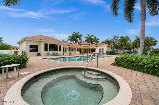 view of pool featuring a patio and an in ground hot tub