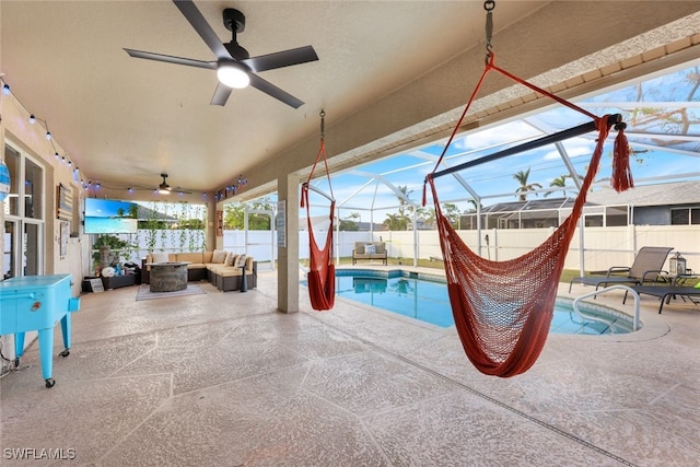 view of patio featuring ceiling fan, glass enclosure, a fenced in pool, and outdoor lounge area