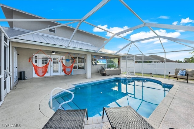 view of pool with a patio area, ceiling fan, and glass enclosure