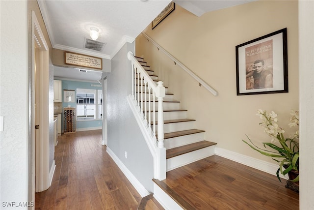 stairs featuring crown molding and wood-type flooring