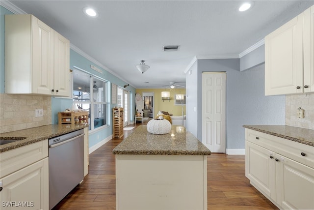 kitchen with stainless steel dishwasher, a center island, white cabinetry, dark stone counters, and ceiling fan