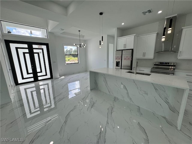 kitchen featuring white cabinets, stainless steel appliances, light stone counters, and pendant lighting