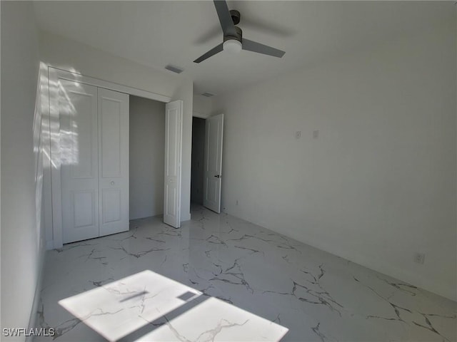 unfurnished bedroom with visible vents, ceiling fan, marble finish floor, and a closet