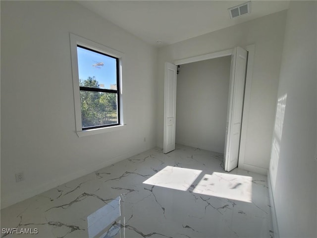 unfurnished bedroom with marble finish floor, baseboards, and visible vents