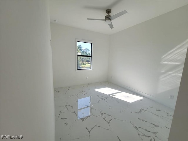spare room with ceiling fan and marble finish floor