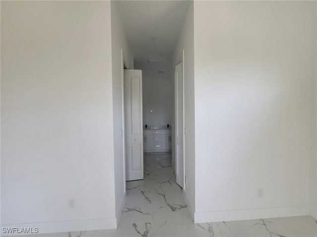 corridor with marble finish floor and baseboards
