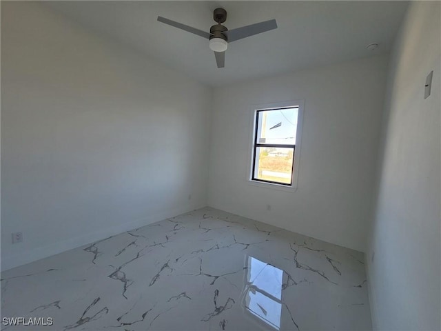 empty room with a ceiling fan and marble finish floor