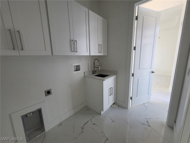 laundry area featuring marble finish floor, a sink, hookup for an electric dryer, washer hookup, and cabinet space