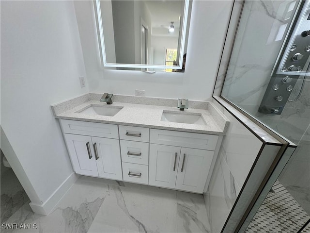 bathroom with double vanity, marble finish floor, a sink, and a stall shower