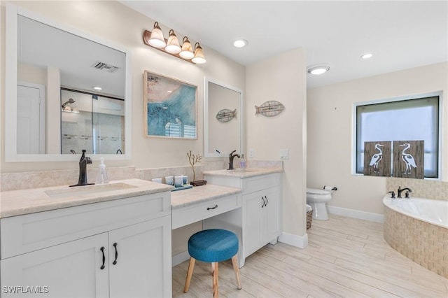 full bathroom featuring toilet, shower with separate bathtub, vanity, and hardwood / wood-style floors