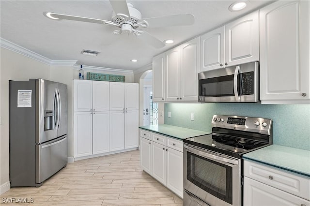 kitchen with white cabinets, ceiling fan, crown molding, and appliances with stainless steel finishes