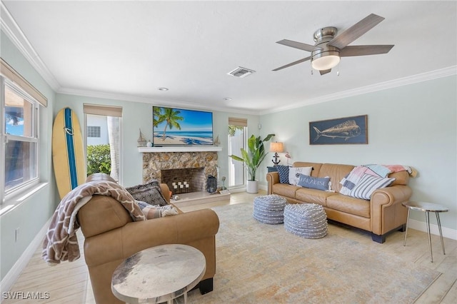 living room with a fireplace, ceiling fan, light hardwood / wood-style floors, and crown molding