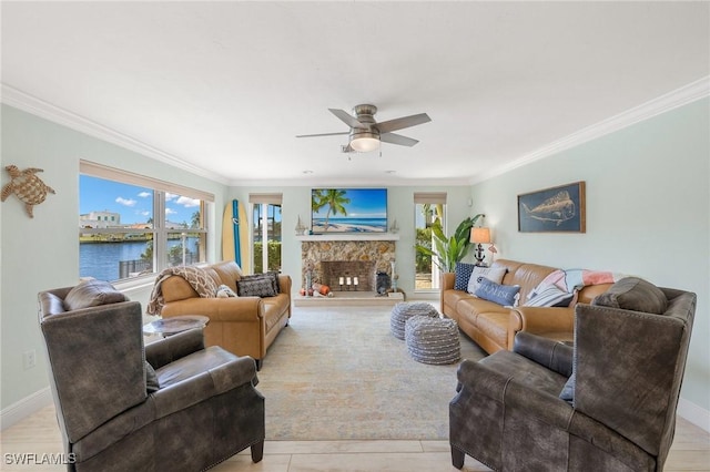 living room with ceiling fan, crown molding, and a fireplace