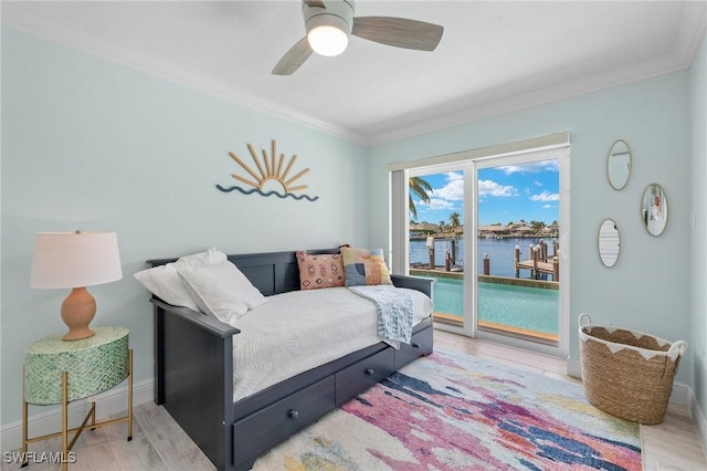 bedroom with ceiling fan, a water view, ornamental molding, and access to exterior