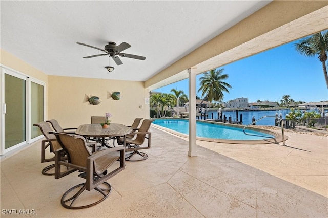 view of pool featuring a patio area, ceiling fan, and a water view