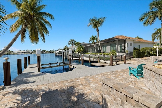 dock area with a lanai and a water view