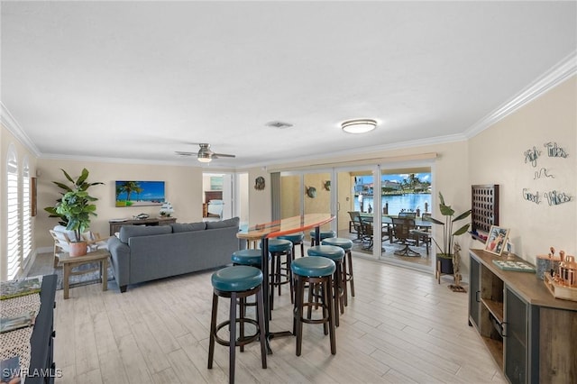 dining space with light wood-type flooring, ceiling fan, and crown molding