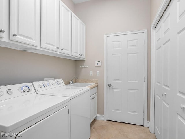 laundry room with cabinets, sink, light tile patterned floors, and washer and clothes dryer