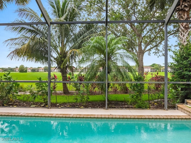 view of swimming pool featuring glass enclosure