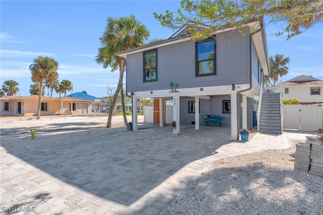 view of front facade featuring driveway, stairway, and a carport