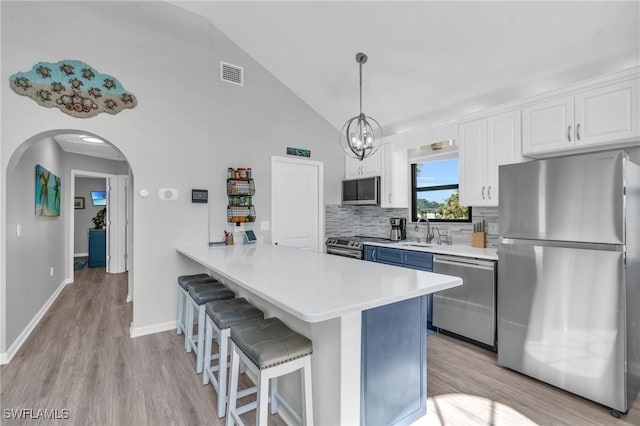 kitchen featuring pendant lighting, light countertops, visible vents, appliances with stainless steel finishes, and white cabinets