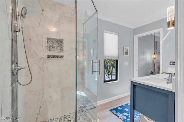 bathroom with a marble finish shower, baseboards, ornamental molding, wood finished floors, and vanity