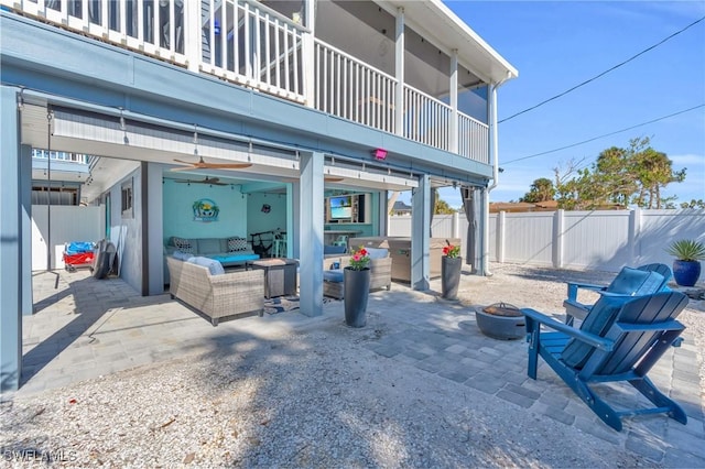 view of patio with an outdoor hangout area, a fenced backyard, a balcony, and a ceiling fan