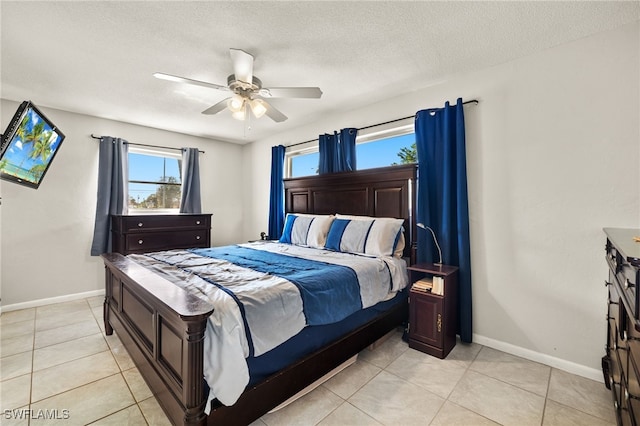 bedroom featuring ceiling fan, a textured ceiling, and light tile patterned floors