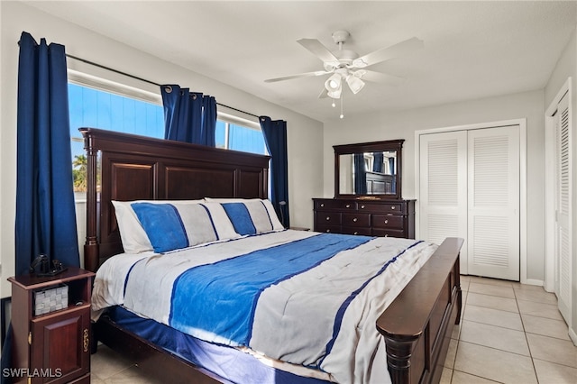 tiled bedroom featuring ceiling fan and a closet