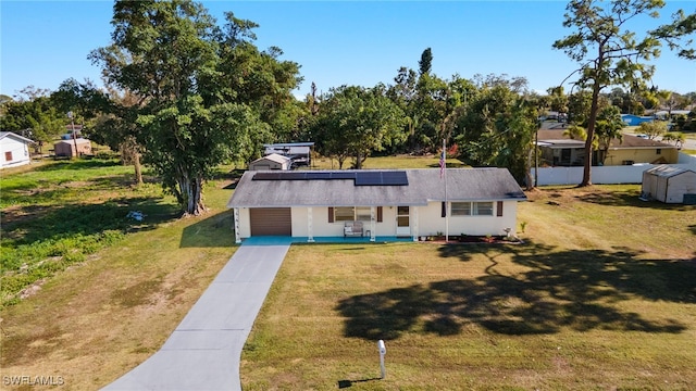 view of front facade featuring solar panels, a front lawn, and a garage