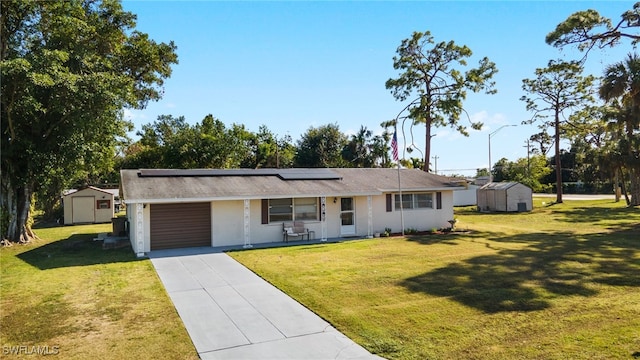 ranch-style house with solar panels, a garage, a front yard, and a storage shed