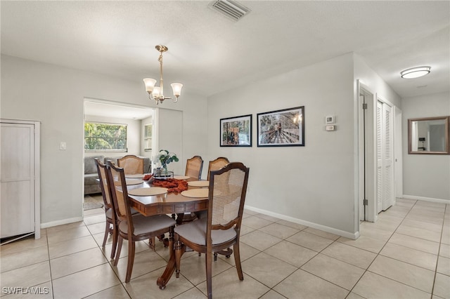 tiled dining space with a chandelier