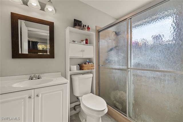 bathroom with toilet, a shower with shower door, and vanity