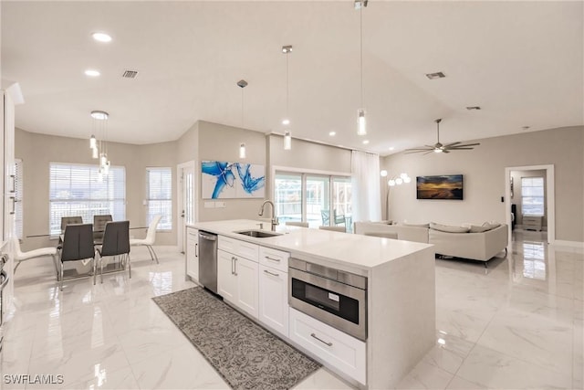 kitchen featuring sink, white cabinetry, ceiling fan, pendant lighting, and appliances with stainless steel finishes