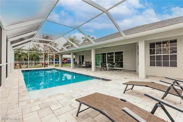 view of swimming pool with a lanai, ceiling fan, and a patio area