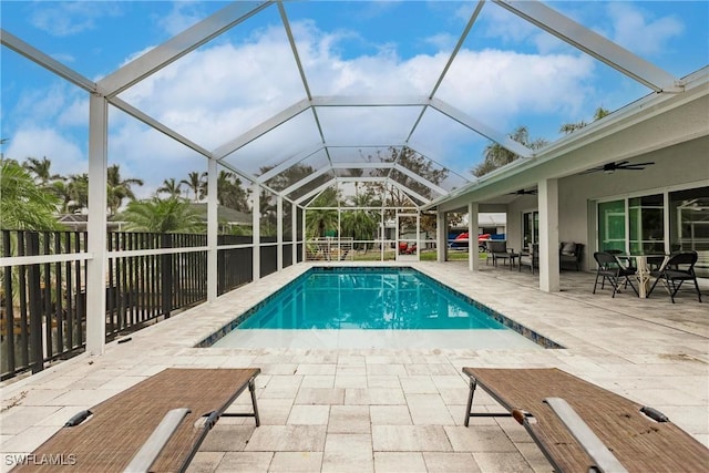 view of pool with ceiling fan, a patio, and glass enclosure