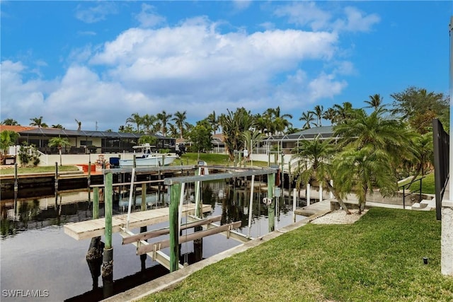 view of dock with a yard and a water view