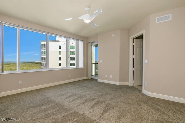 carpeted spare room featuring ceiling fan