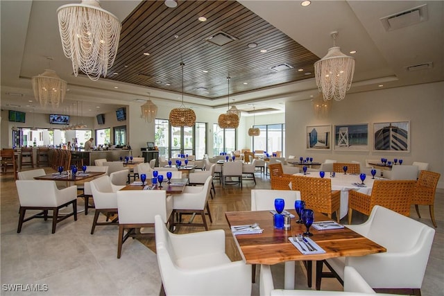 dining space featuring a raised ceiling and an inviting chandelier