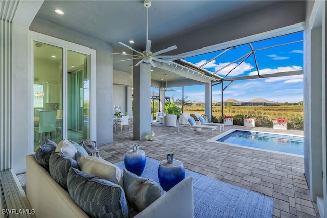 view of patio with glass enclosure, outdoor lounge area, and ceiling fan