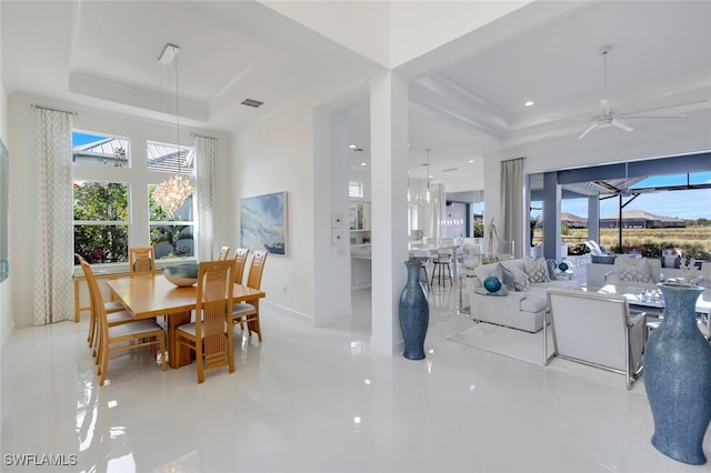 dining room featuring ceiling fan and a tray ceiling