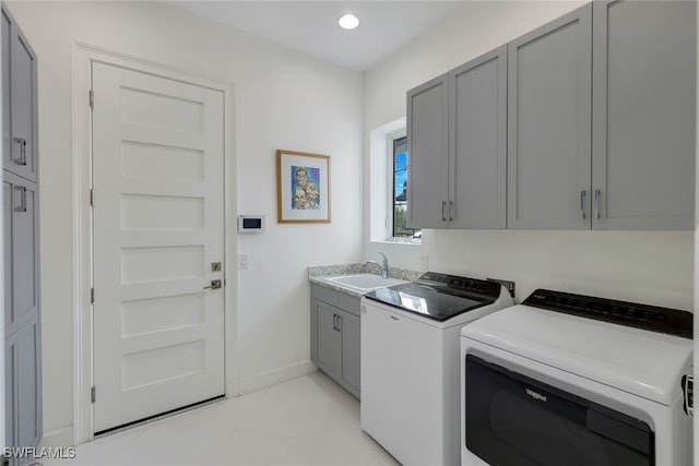 laundry area with sink, washing machine and clothes dryer, and cabinets