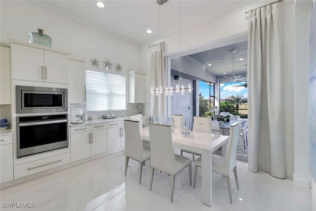 dining area featuring a wealth of natural light, light tile patterned floors, crown molding, and a notable chandelier