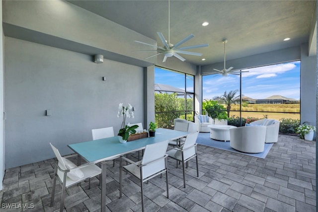 sunroom / solarium featuring ceiling fan