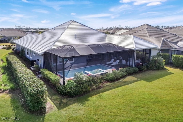 rear view of property with a lawn, a swimming pool with hot tub, and glass enclosure