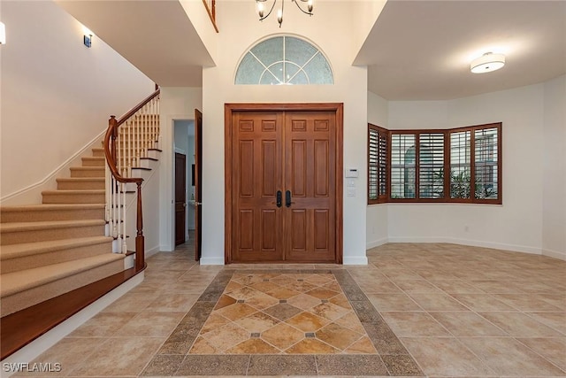 tiled foyer entrance featuring a notable chandelier