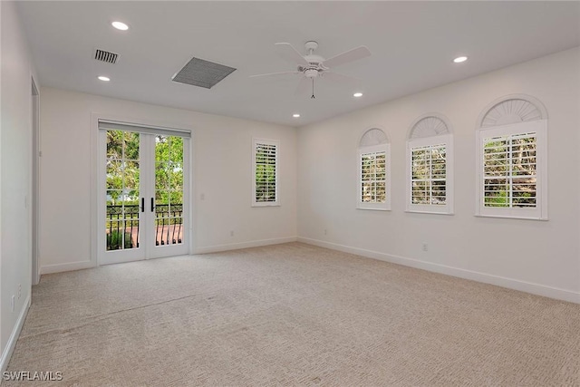 empty room featuring light colored carpet, french doors, and a wealth of natural light